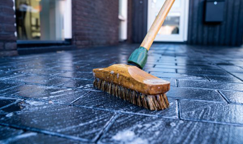 Horizontal,Close-up,Image,Of,Broom,Cleaning,Dark,Concrete,Block,Floor